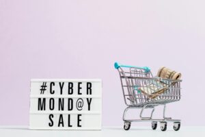 pexels photo 5632364 5632364 Shopping cart filled with cash beside a Cyber Monday sale sign, perfect for retail promotions.